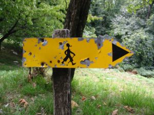 Gelbes Schild zeigt Wanderern die Richtung